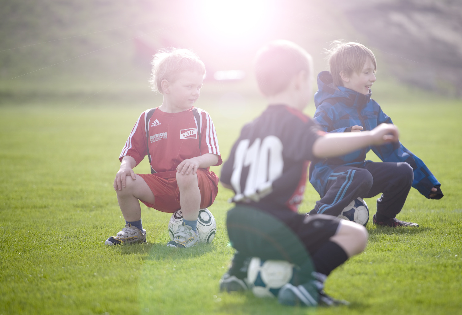 Barn sitter på fotbollar