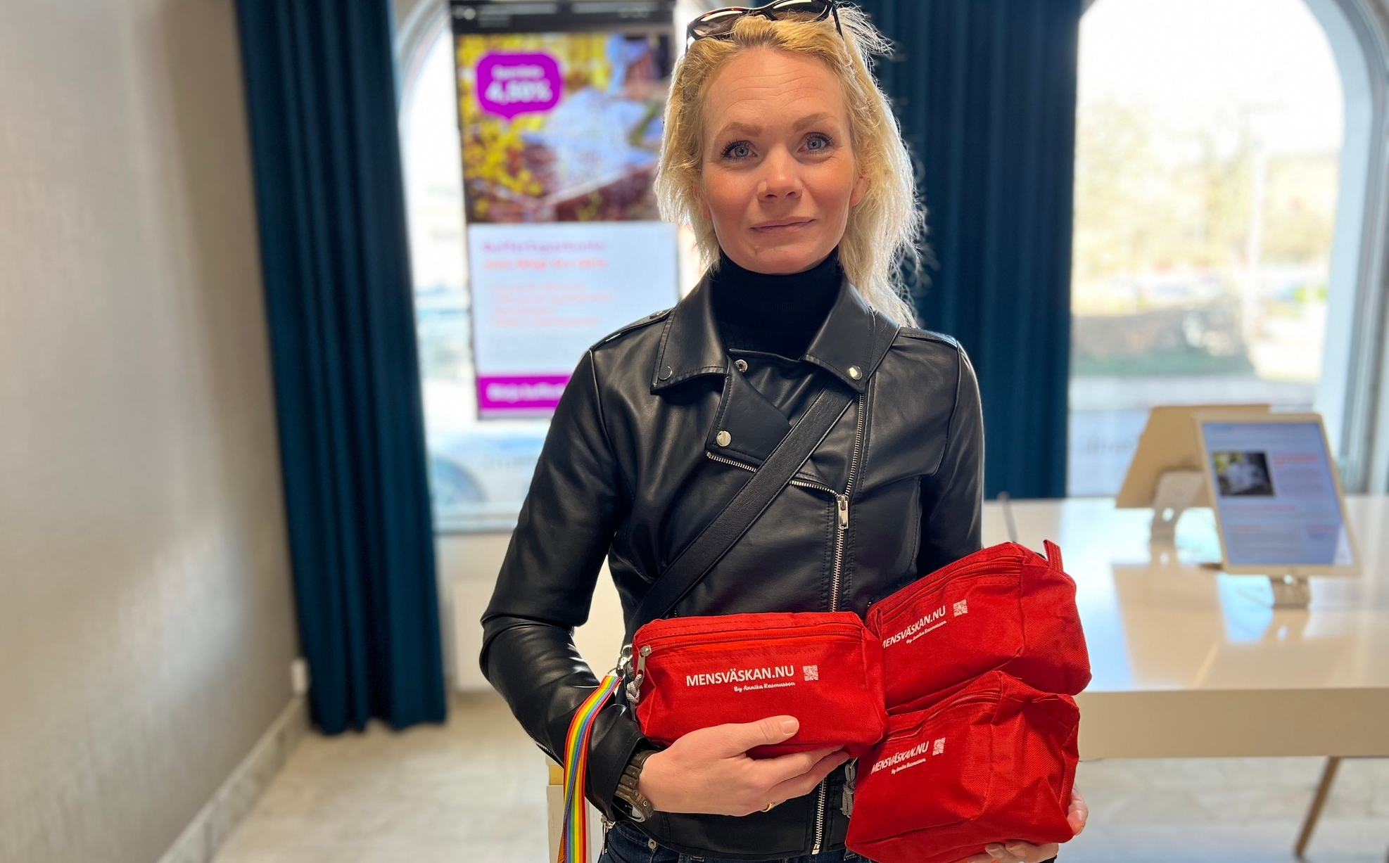 en kvinna håller tre röda mensväskor