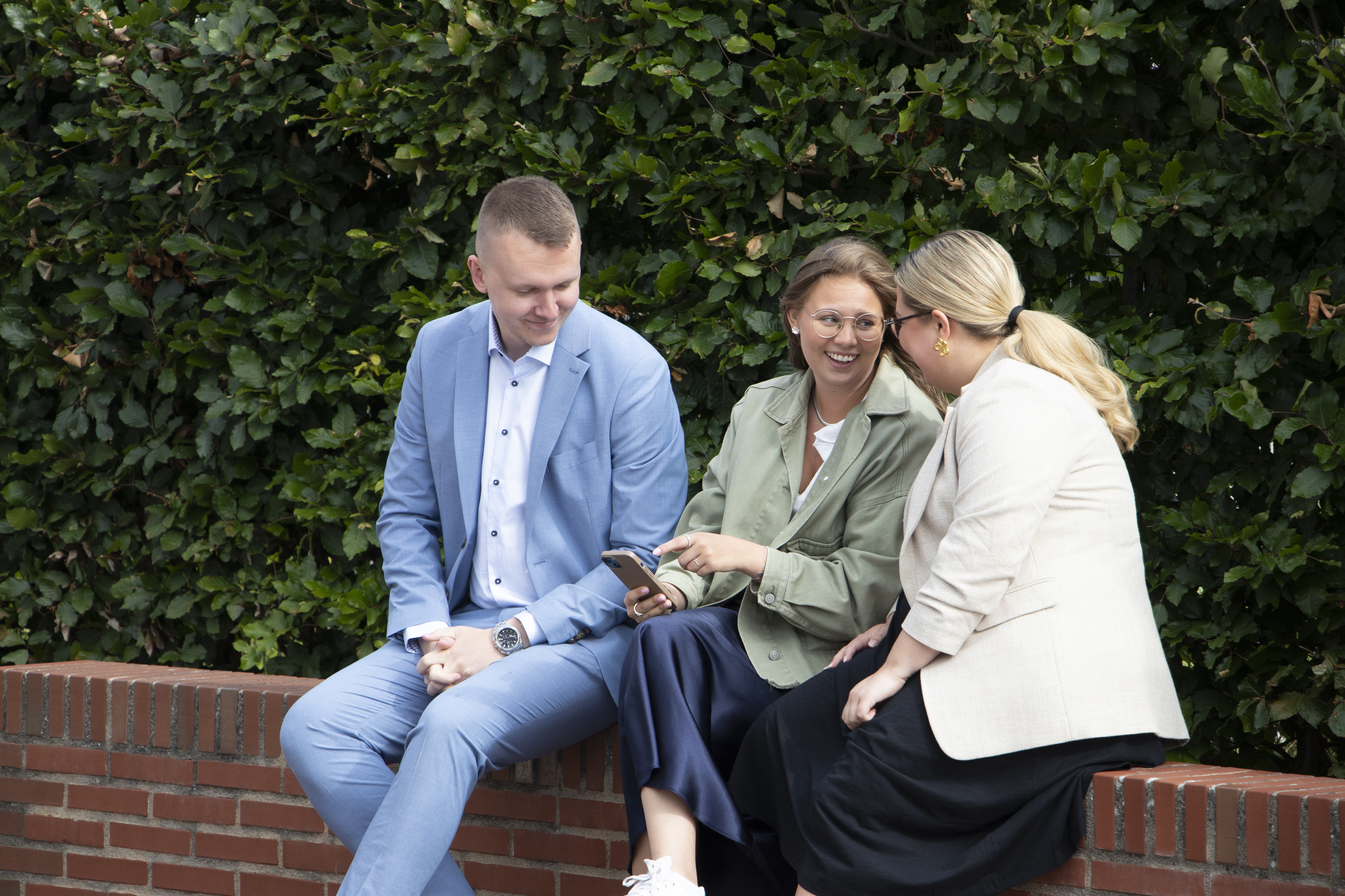 Tre ungdomar kollar mobilen